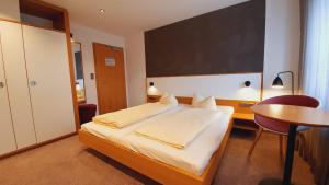 Schlafzimmer mit einem Bett, einem Schreibtisch und einem Tisch in der Unterkunft Hotel Restaurant Adler in Immenstaad am Bodensee
