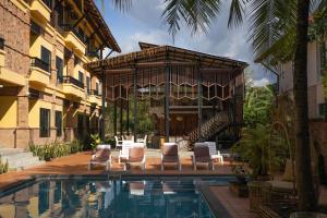 un complejo con piscina, sillas y un edificio en Motive Cottage Resort, en Khao Lak