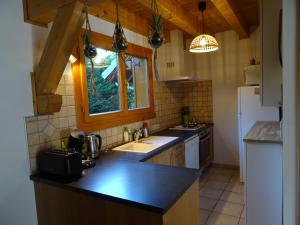 - une cuisine avec un évier et un comptoir dans l'établissement Chalet douillet au cœur du Champsaur, à Poligny