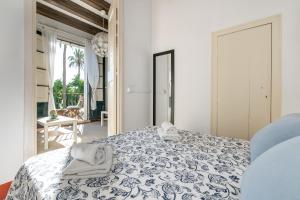 ein Schlafzimmer mit einem blauen und weißen Bett mit Handtüchern darauf in der Unterkunft Vistamar 2: Primera línea de mar con gran terraza in Sitges