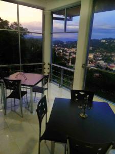 a dining room with a table and chairs and windows at Sky Valley in Kandy