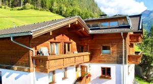 a wooden house with a balcony on a mountain at Berghaus Egg in Jerzens