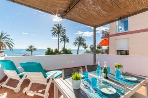 a dining table and chairs on the balcony of a villa at Vistamar 2: Primera línea de mar con gran terraza in Sitges