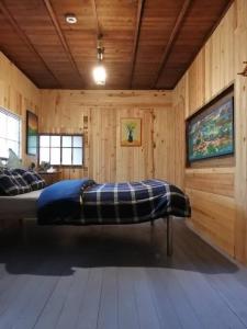 a bedroom with a bed in a wooden room at Twinkle Villa in Kokuryō