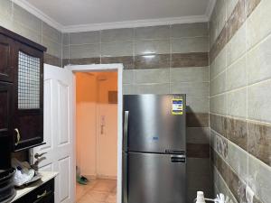 une cuisine avec un réfrigérateur en acier inoxydable dans une pièce dans l'établissement Gardenia city cairo, au Caire