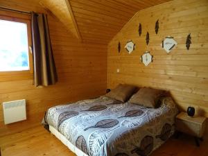 - une chambre avec un lit dans une cabane en rondins dans l'établissement Chalet douillet au cœur du Champsaur, à Poligny