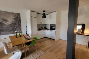 une cuisine et une salle à manger avec une table et des chaises dans l'établissement Le Bord de Seine - Paris, à Paris 2 autres photos