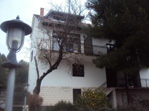 - un bâtiment blanc avec un balcon et un éclairage de rue dans l'établissement Apartments Petar, à Blace