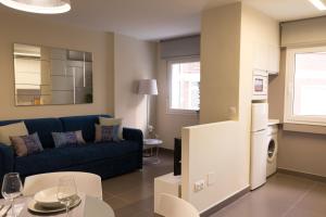 a living room with a blue couch and a table at Living4Malaga Centro Hist&oacute;rico y Playa in M&aacute;laga