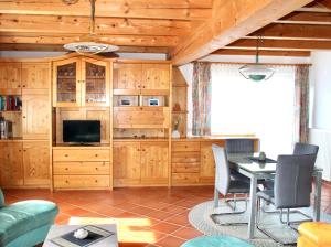 a living room with a table and a tv at Berghaus Egg in Jerzens