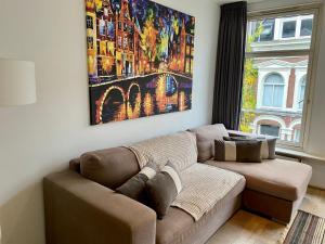 a living room with a couch and a painting on the wall at Residences Old South in Amsterdam