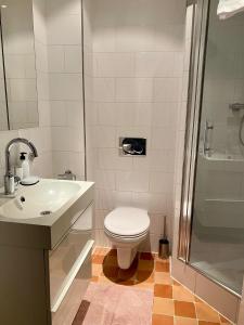 e bagno con servizi igienici, lavandino e doccia. di Residences Old South ad Amsterdam