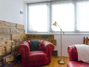 シラクーサにあるCasa Afrodite Exclusive Penthouseのリビングルーム(赤い椅子、ランプ付)