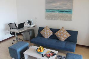 ein Wohnzimmer mit einem blauen Sofa und einem Tisch in der Unterkunft Wharf Side Inn in Pemba