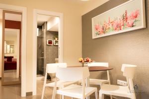 a dining room with a table and white chairs at Living4Malaga Centro Histórico y Playa in Málaga +47 photos