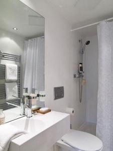 a white bathroom with a sink and a mirror at VISIONAPARTMENTS Binzmühlestrasse 48 - contactless check-in in Zürich