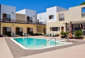 a swimming pool in front of a building at Aparthotel Novo Sancti Petri in Chiclana de la Frontera