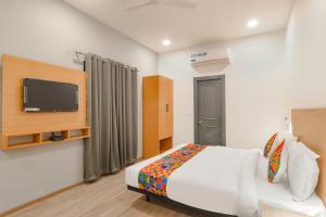 a bedroom with a bed and a flat screen tv at FabHotel BSA in Lucknow