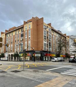 un gran edificio de ladrillo en una calle de la ciudad con un semáforo en Apartamentos Prestige Malaga Suites III, en Málaga