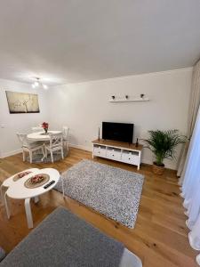 マラガにあるApartamentos Prestige Suites Málaga IIIのリビングルーム(テレビ、テーブル付)