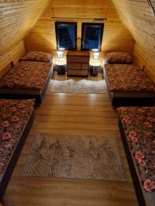 a attic room with four beds and two windows at Chata Tokarka - Richňavské jazerá in Štiavnické Bane