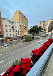 a balcony with red flowers on a city street at Apartamentos Prestige Malaga Suites III in Málaga