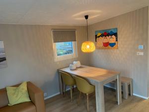 a dining room table and chairs in a room at Chalet2rent Ameland in Ballum