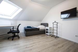 Un dormitorio con una cama y un escritorio y una ventana. en Luxury Saarbrücken Workers Rooms, en Saarbrücken