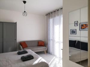 a white bedroom with a bed and a couch at Saxony house in Verbania