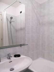 ein weißes Bad mit einem Waschbecken und einer Dusche in der Unterkunft Saxony house in Verbania