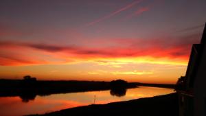 a sunset over a river with the sky at Pension Remenar & Lorenz in Zeithain +3 photos