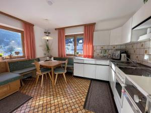 a kitchen with a table and chairs and a dining room at Sepp, Haus in Finkenberg