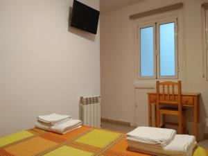 Habitación con mesa, silla y ventana en Pension Dominguez en Madrid