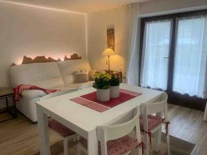 sala de estar con mesa blanca y sofá en Pinzolo, grazioso appartamento, wellness a 100 metri, en Pinzolo