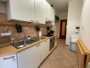 a kitchen with white cabinets and a sink at DEA DREAMS San Siro 27 Apartment in Milan