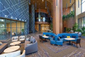 a lobby with tables and chairs in a building at SUN & MOON, Riverside Hotel in Phnom Penh