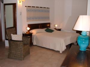 a bedroom with a bed and two tables and a lamp at Hotel Spartivento in Chia