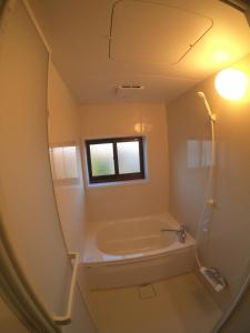 uma casa de banho com uma banheira, um lavatório e uma janela em Bridge33 CAFE AND HOSTEL em Takagi