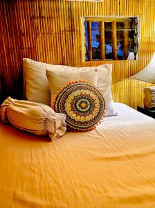 łóżko z poduszką i poduszkami w obiekcie Balai Consuelo Pamingwitan Campground w mieście Buliran