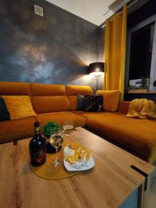 a living room with a couch and a table with wine glasses at Ropienka Ski in Ustrzyki Dolne