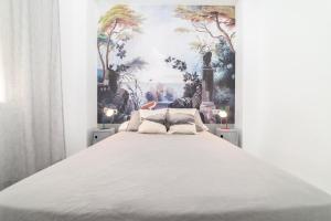 um quarto com uma cama grande e uma pintura na parede em Maria´s Home em Málaga