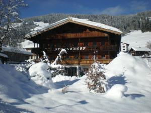 a large wooden building covered in snow at Pension Steinerhof in Oberau