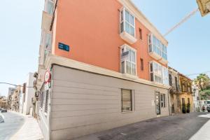 ein orangefarbenes Gebäude mit einer weißen Garage neben einer Straße in der Unterkunft Maria´s Home in Málaga