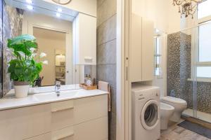 uma casa de banho com um lavatório e uma máquina de lavar roupa em Lovely flat - Orti 16 em Milão