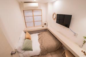 東京にあるビジネスホテル韓国館のソファ、薄型テレビが備わる小さな客室です。