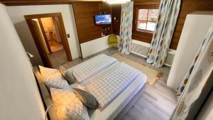 een kleine kamer met een bed en een televisie bij Maple Appartement in Mayrhofen