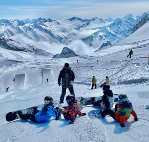 een groep mensen die bovenop een met sneeuw bedekte berg zitten bij Maple Appartement in Mayrhofen