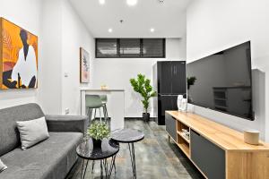 a living room with a couch and a flat screen tv at Modern renovated 1 bedroom apartment w Bomb Shelter Central TLV M2 in Tel Aviv