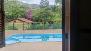- une vue sur la piscine depuis la porte d'une maison dans l'établissement Sítio Alazão, à Moeda