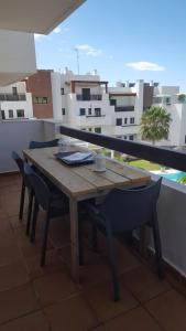 einen Holztisch und Stühle auf dem Balkon in der Unterkunft Nice apartment within walking distance to the center in La Cala de Mijas